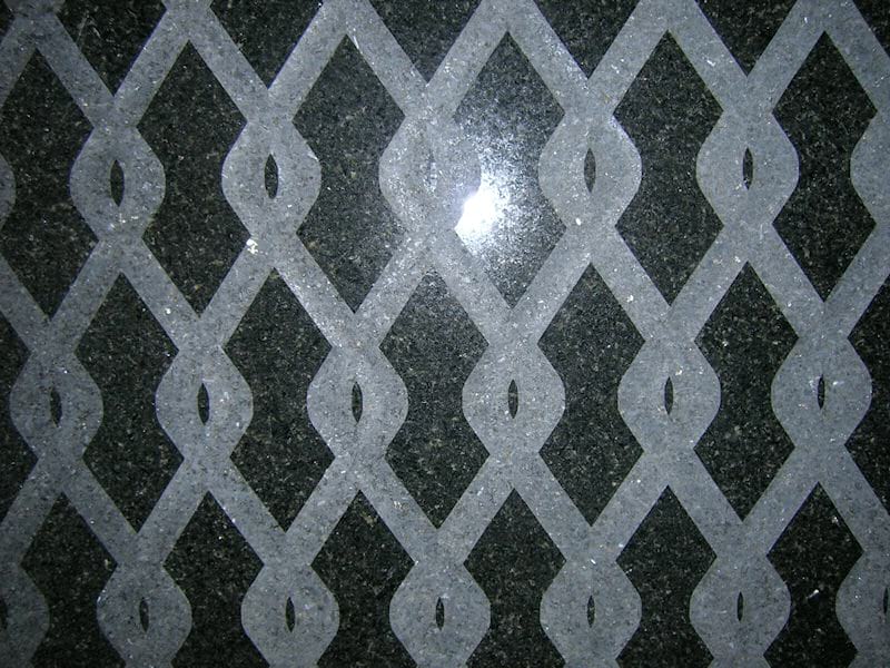 Percoco's Chain-link pattern of concave smooth tooled interlocking waves shown on a piece of San Gabriel granite