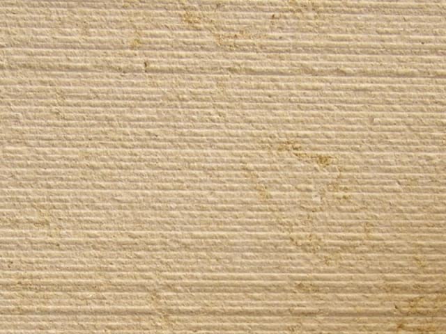Percoco's Scarpaletto (Fine) finish shown on a piece of Halila Gold Limestone