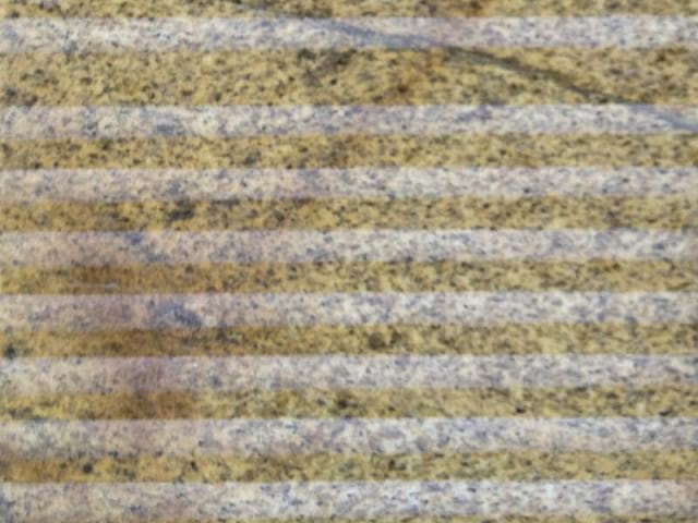 A linear alternating pattern of flat polished and lighter smooth tooled concave surfaces