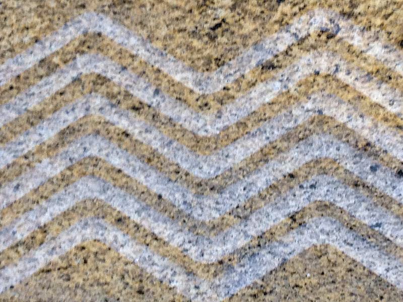 Percoco's Wave pattern of alternating flat polished and concave smooth tooled surface shown on a piece of Juperana Santa Ceceila granite